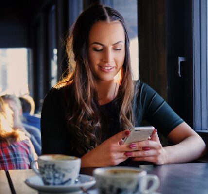 A woman texting an SMS in a cafe.