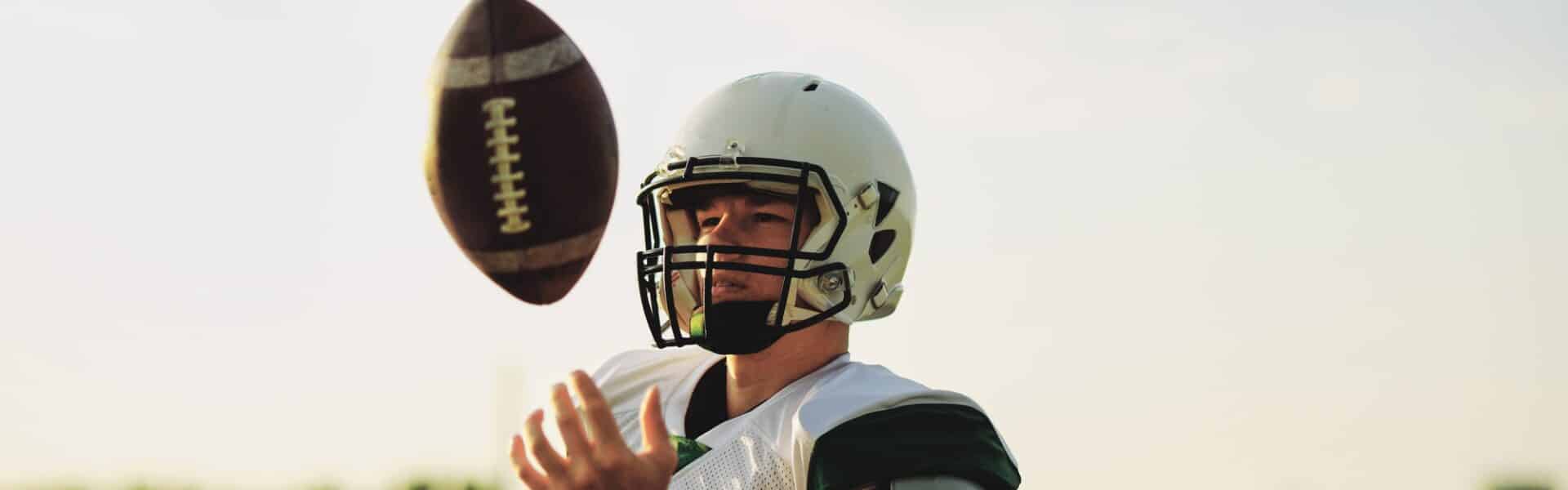 American football quarterback tossing a ball in the air