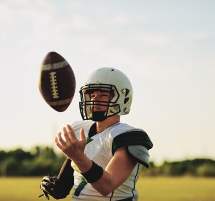 American football quarterback tossing a ball in the air