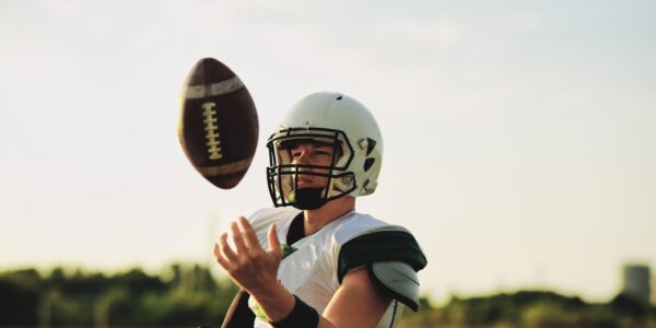 American football quarterback tossing a ball in the air