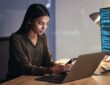 Laptop, phone and business woman on coding, software development and programming script for cyberse