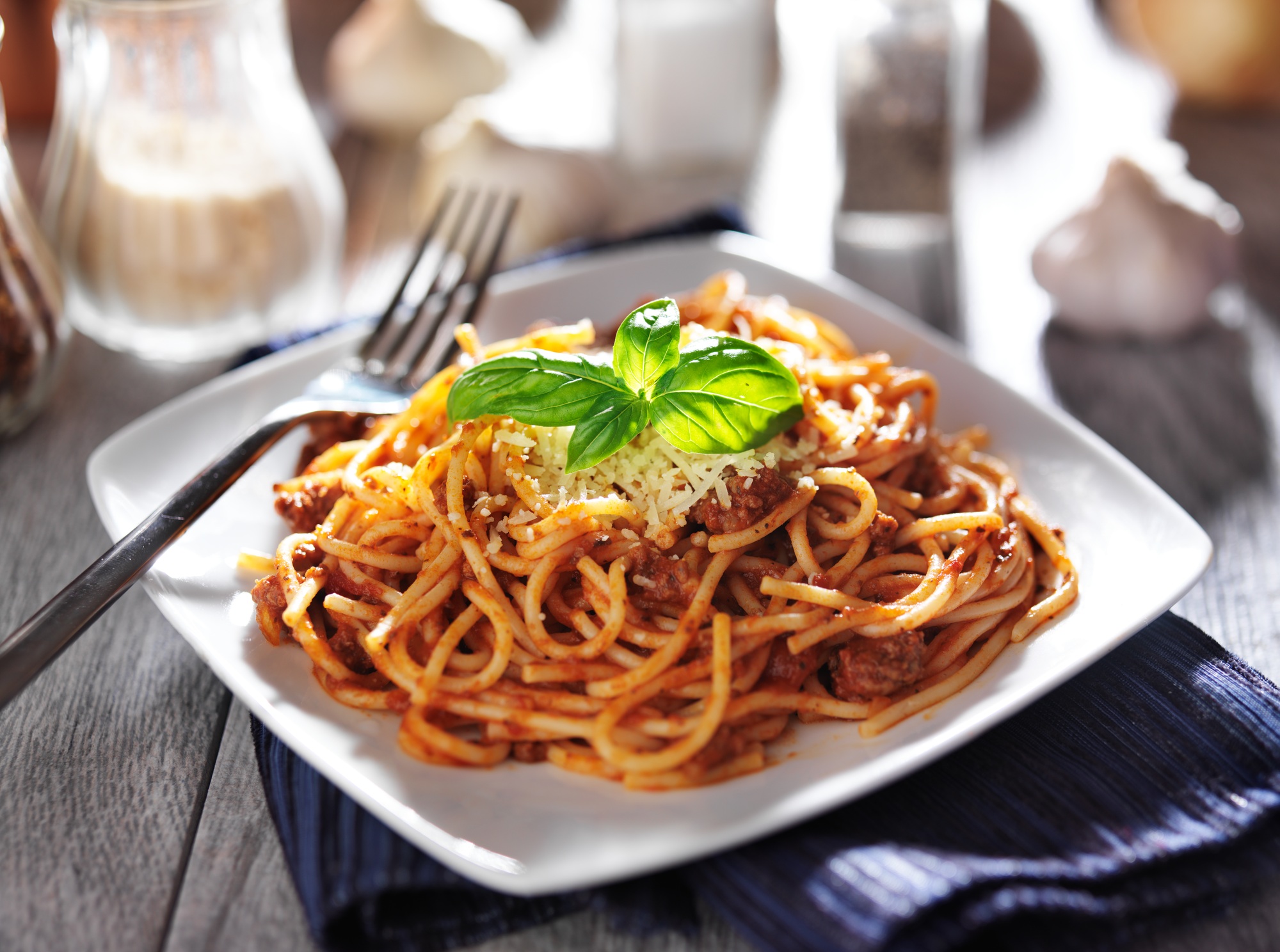 spaghetti in bolognese sauce with basil garnish